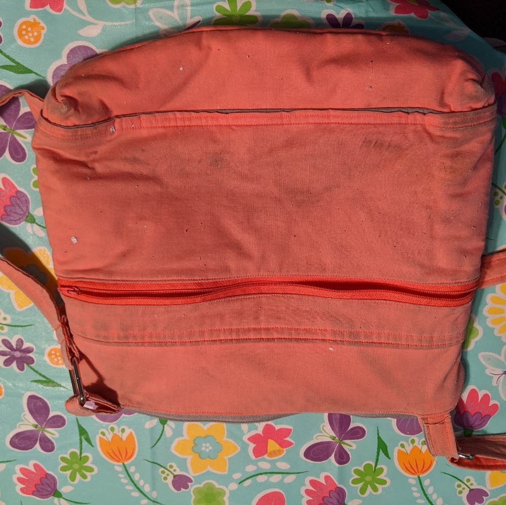 Salmon colored crossbody purse.